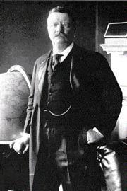 an old photo of a man standing in front of a globe