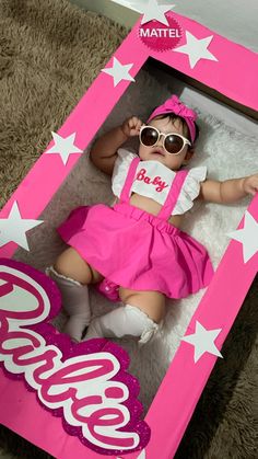 a baby is laying in a pink box with white stars and the word boo on it