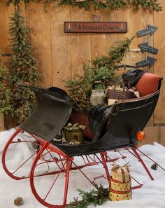 a sleigh filled with christmas presents in front of a wooden wall and sign