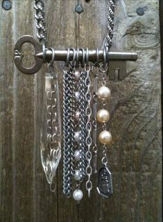 an old key is attached to a chain with charms and keys hanging from it's sides