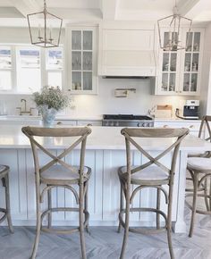 three chairs sitting in front of a kitchen island