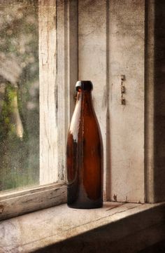 a brown bottle sitting on top of a window sill