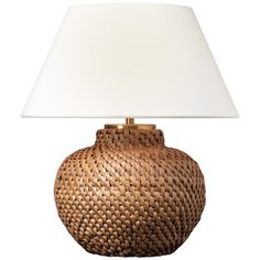 a lamp that is on top of a white table cloth next to a brown basket