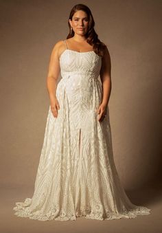 a woman in a white dress posing for the camera with her hands on her hips