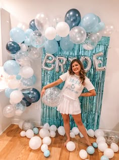 a woman standing in front of balloons and streamers with the word bride on it