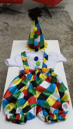 a birthday cake made to look like a clown's hat and dress up outfit