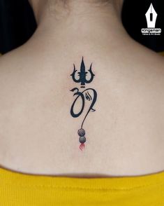 a woman with a tattoo on her upper back shoulder and the word om written in black ink