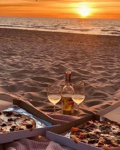 two pizzas and wine on the beach at sunset