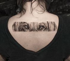 a woman's back shoulder with an eye tattoo on it