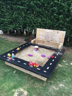 an outdoor sandbox with toys in it