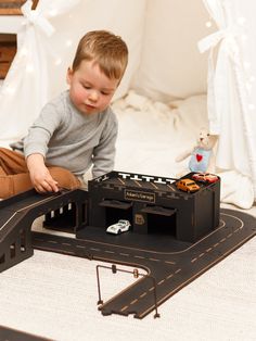 a young boy playing with a toy train set