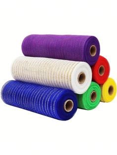 four rolls of colorful yarn on white background with one roll in the middle and two rolled up