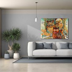 an owl painting hangs on the wall above a couch in a living room with potted plants