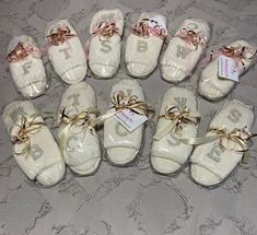 baby booties are laid out on the bed with ribbons around them and tags attached to them