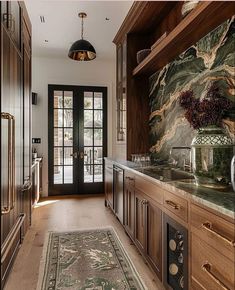 a large kitchen with marble counter tops and wooden cabinetry, along with an area rug on the floor