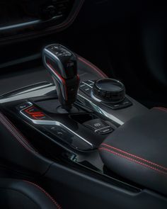 the interior of a modern car with red stitching