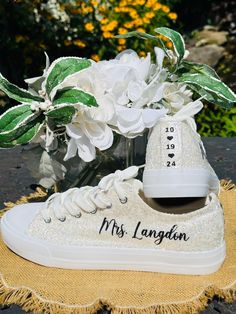 Hand Glittered unbranded canvas sneakers glittered in a gorgeous chunky white mix called *bungalow* with black glitter personalization of your choice.  Shown with white glitter trim, optional. Made to order. Personalization is added in black glitter to include name on the outside of each sneaker and date down the back as shown. Please include custom info in the order notes. Should you desire different placement or options, please send us a message. Glitter is high quality and heat set for minimal glitter loss and lasting quality, though, you may see glitter shedding the first time you wear/try on your shoes.  Although we aim to remove every loose piece of glitter prior to shipment, the shipping process s well as putting them on and adjusting the laces can disrupt the glitter and cause some Bride Sneakers, Sparkle Sneakers, Bridal Parties Colors, Black Writing, Birthday Special, Glitter Shoes, Sneakers Athletic, White Glitter, Black Glitter