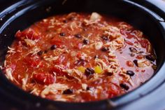 a crock pot filled with chili and chicken in the slow cooker, ready to be cooked