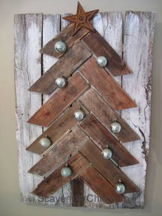 a christmas tree made out of wooden planks with lights on the bottom and an ornament at the top