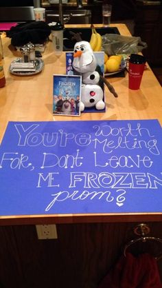 a frozen princess sign on a table next to a cup and some other items in front of it