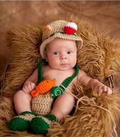 a baby wearing a crochet hat and green pants with a fish on it