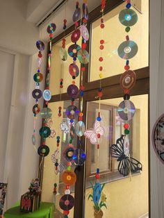 a window decorated with glass beads and other items hanging from it's side wall