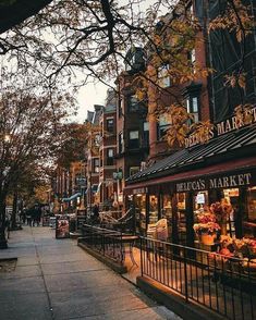 the sidewalk is lined with shops on both sides