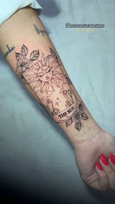 a woman's arm with a sun and flowers tattoo on the left side of her arm