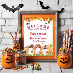 an orange framed sign with candy and candies in front of it, surrounded by halloween decorations