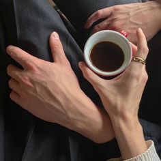 two hands holding a cup of coffee