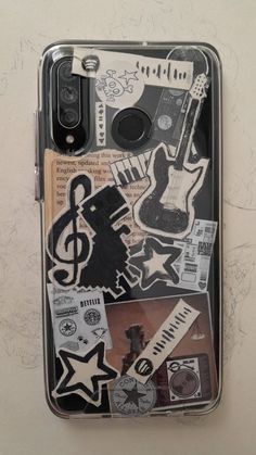 a cell phone case with various stickers and music notes on the back, sitting on a wall