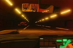 a car driving through a tunnel with yellow lights on the ceiling and an image of a woman's face in the mirror