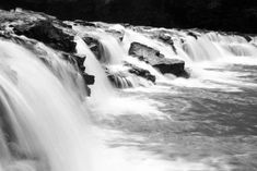 black and white photograph of water cascading over rocks