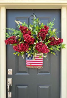 a patriotic flower basket hanging on the front door