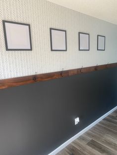 a wall with three pictures hanging on it's side and two hooks in the middle