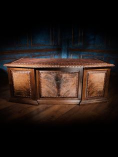 an old wooden chest with carvings on the front and sides, against a dark background