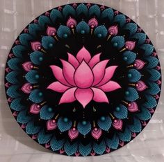 a pink flower on a black and blue circular design with white tiles in the background