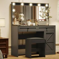 a dressing table with lights on it and a stool in front of the vanity mirror