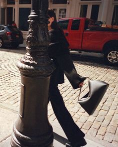 a woman is walking down the street with her purse