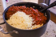 a pan filled with pasta and cheese on top of a counter