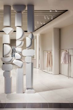 the interior of a clothing store with white walls and columns