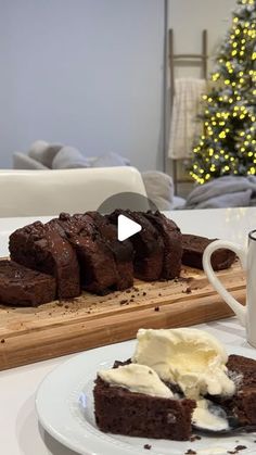 a white plate topped with brownies next to a cup of ice cream and a christmas tree