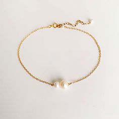 Simple and elegant, the Margot Anklet features genuine freshwater pearls in an asymmetric design set in dainty 14k gold filled chain. -- freshwater pearls length: 8.5" plus 2" extender cable chain link 14k gold filled Gold Anklets With Pearl Charm For Gift, Gold Anklets With Pearl Charm As Gift, Minimalist Pearl Bracelet With Adjustable Chain, Adjustable Minimalist Pearl Chain Anklet, Elegant Pearl Anklets With Pearl Chain, Elegant Anklets With Extender, Elegant Pearl Chain Anklets, Dainty Pearl Gold Anklets, Gold Pearl Anklets As Gift