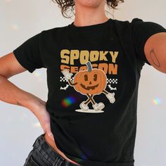 Grab your cute spooky Pumpkin babytee!  Perfect gift for Halloween lovers 🎃. ++ PLEASE READ++ 🤍 ABOUT THE Y2K BABY TEE: * Made with 100%, (5.3 oz/yd² (180 g/m heavy cotton. * This is a made-to-order T-shirt. * The shirt is Gildan 5000B. * Made using ethically grown and harvested cotton.  📏 SIZES: This is a CHILD'S T-shirt so please check the measurements table in the pictures to ensure a perfect fit.  ❗ It is not a crop top. Tip:  If unsure, grab your favorite baby tee, measure it while it's Spooky Halloween Graphic Print T-shirt, Spooky Halloween Graphic T-shirt, Cute Halloween Graphic Print T-shirt, Cute Halloween T-shirt With Screen Print, Spooky Halloween T-shirt With Cartoon Print, Halloween Lovers, Y2k Baby Tee, Spooky Pumpkin, Baby T Shirts