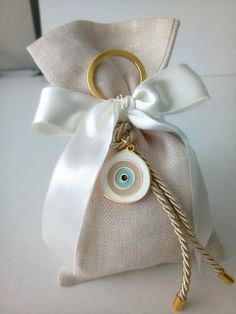 a white bag with a gold ring and an evil eye on it