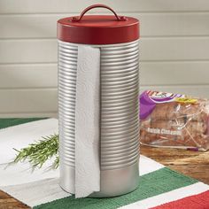 a stack of tins sitting on top of a table next to a bag of chips