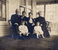 an old black and white photo of a family posing for a picture on the porch