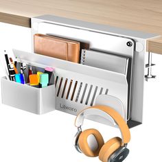 an office desk with headphones, pens and pencils in the holder next to it