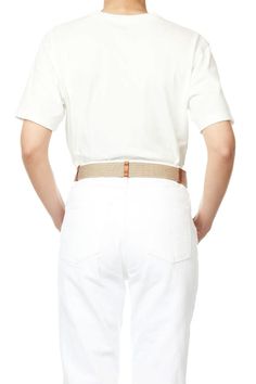 the back view of a man wearing white pants and a t - shirt, with his hands on his hips