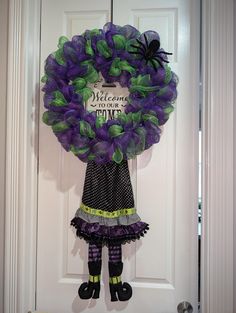 a purple and green wreath hanging on the front door